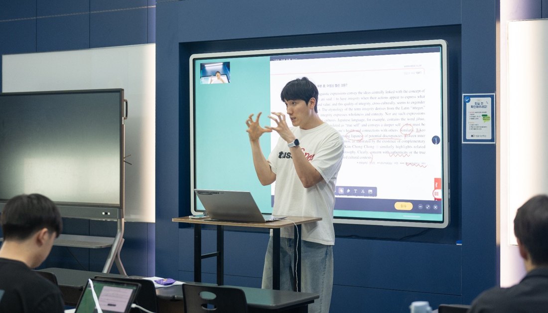전자칠판 앞에서 설명하는 수업 장면